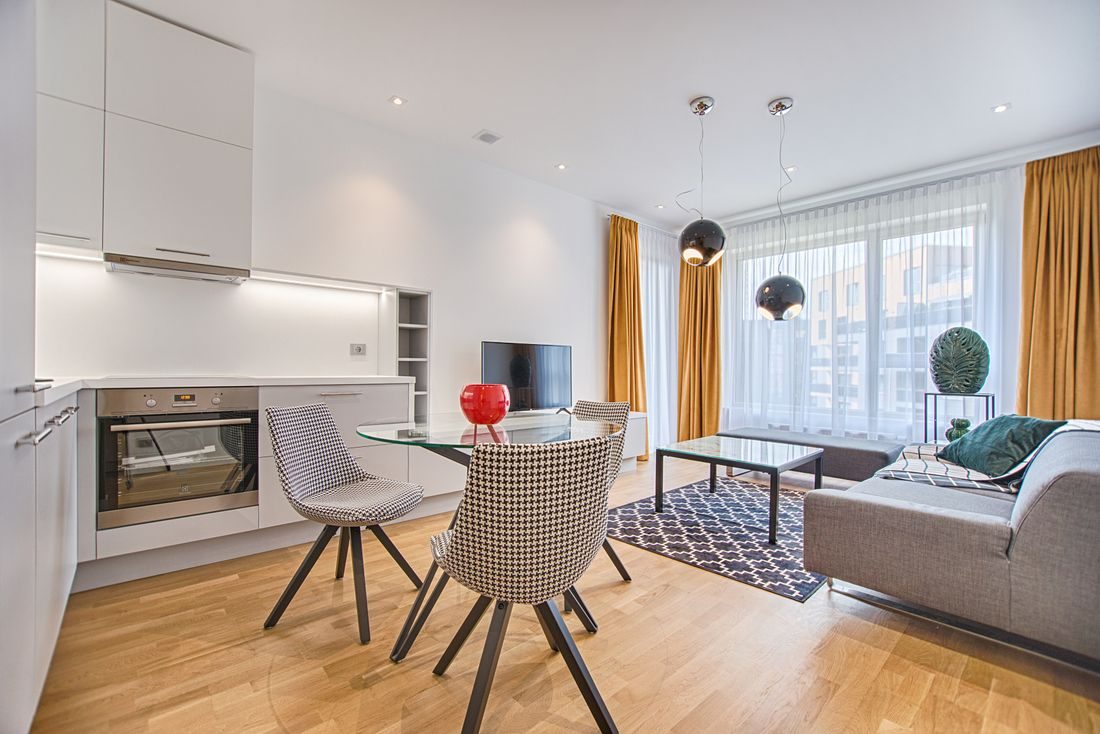 A small modern apartment living area with a dining table and sofa