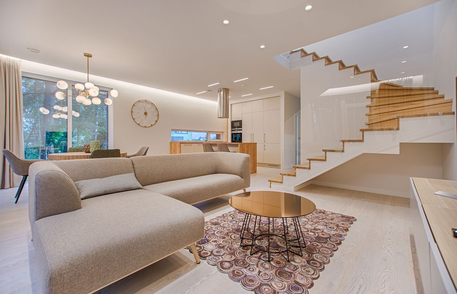 A bright, tidy open plan living room with a pale sofa and clean wood floors