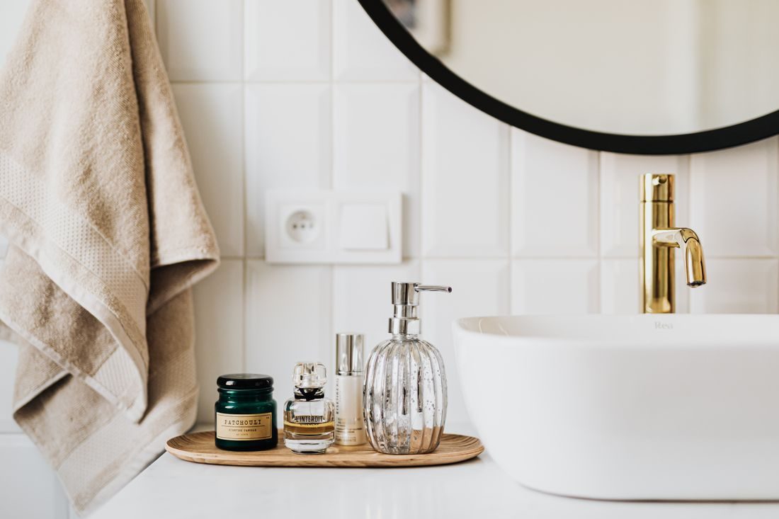 A clean bathroom vanity with a folded towel and a brass faucet