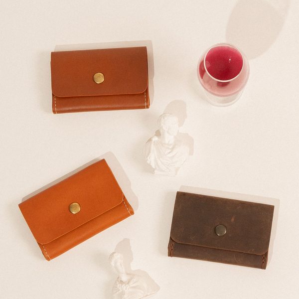 Three snap card cases in cognac, natural and chestnut on cream paper