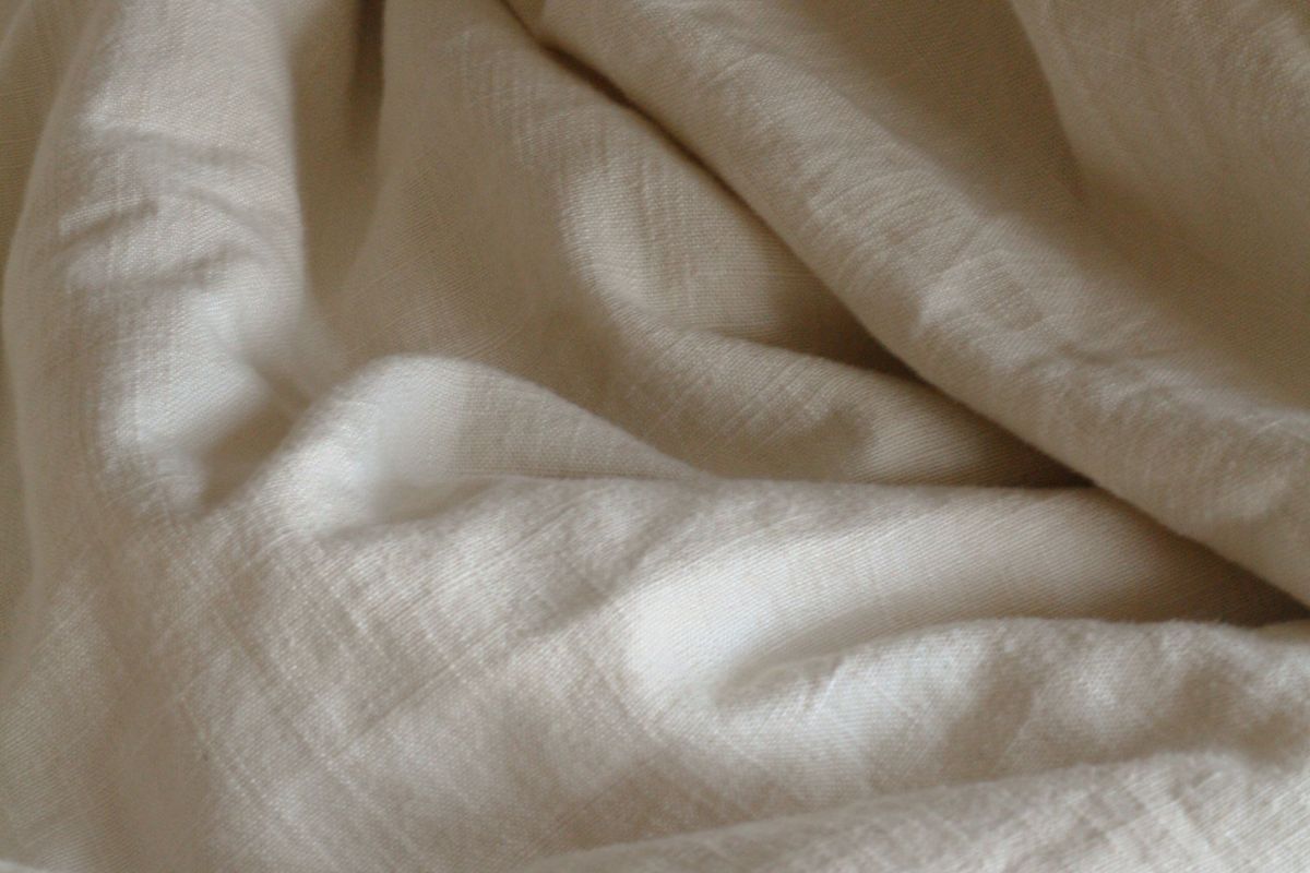Soft folds of natural linen in warm, low light