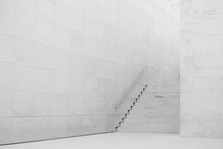 A minimal steel stair set against a large white rendered wall, reduced almost to a drawn line.