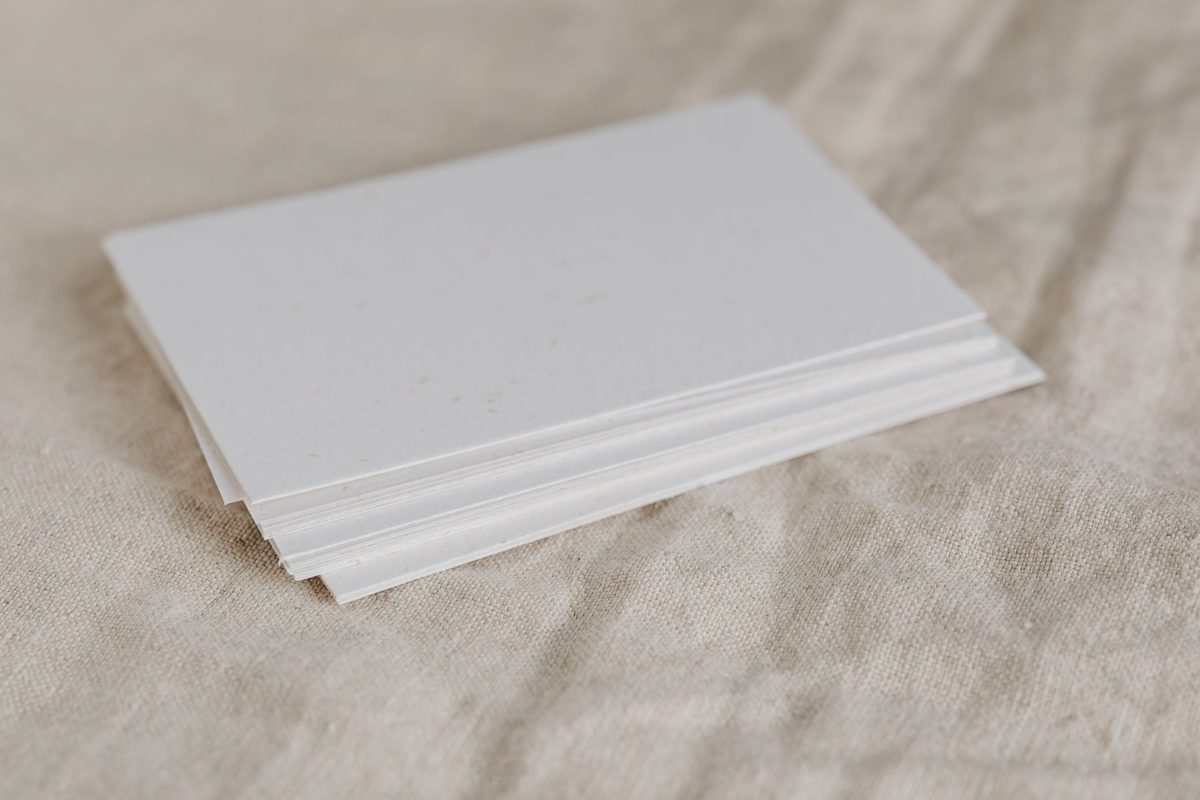 A neat stack of blank white printing paper resting on a linen cloth